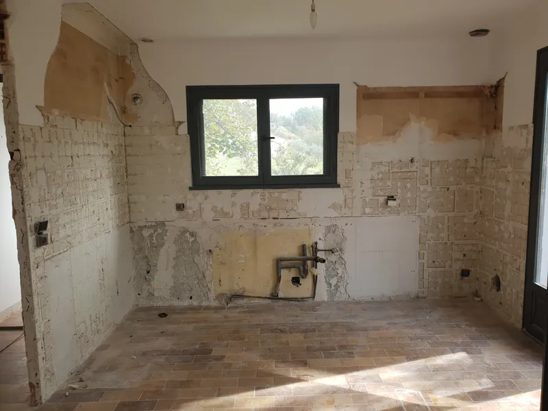 Avant travaux : cuisine d'une maison ancienne, murs décroûtés