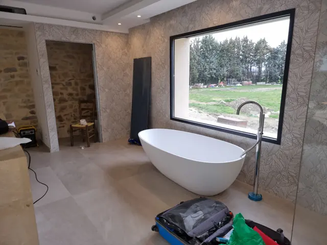 Baignoire îlot devant une fenêtre sur la campagne