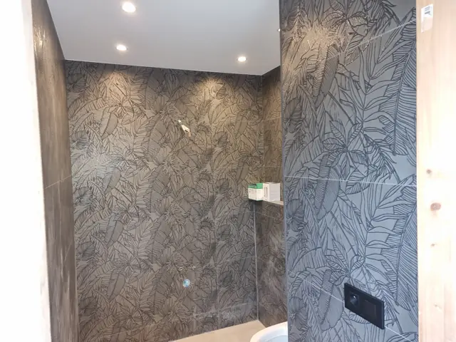 Douche à l'italienne avec spots encastrés et carrelage à motifs