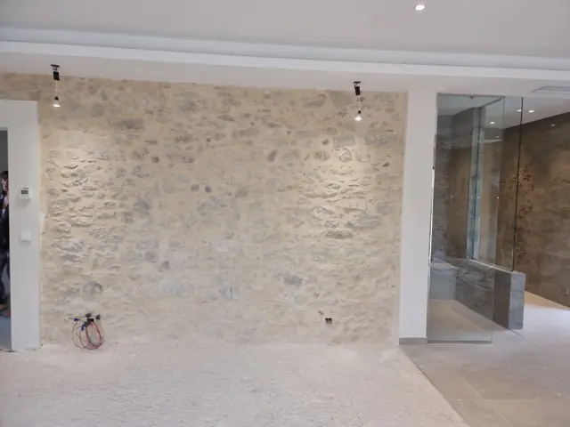 Mur en pierre apparente mis en valeur par des spots