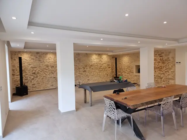 Salle de réception en pierre avec corniches lumineuses et spots encastrés